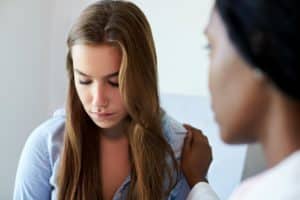 teen girl talking to a counselor about common mental health problems in teens