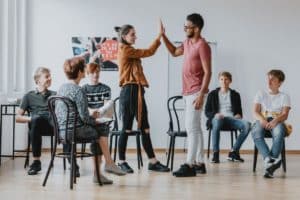 teens high fiving in teen mental health treatment