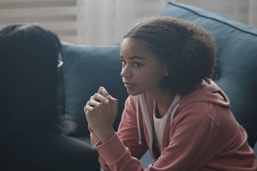 girl on couch talking with a therapist about teen crisis intervention