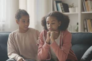 girl on couch with friend talking about how to stop bullying